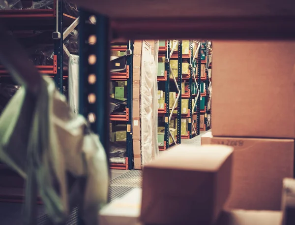 Caixas e caixas em prateleiras em um armazém — Fotografia de Stock