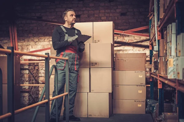 Storekeeper com lista de escolha manual em um armazém — Fotografia de Stock