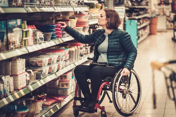 Woman in a wheelchair in a department store — Stock Photo, Image