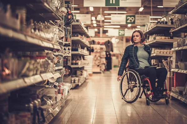 Donna su una sedia a rotelle in un grande magazzino — Foto Stock