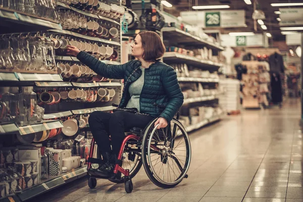 Vrouw in een rolstoel in een warenhuis — Stockfoto