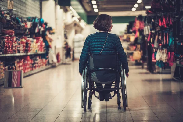 Vrouw in een rolstoel in een warenhuis — Stockfoto