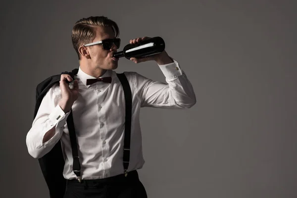 Homme habillé en costume noir avec bouteille de vin — Photo