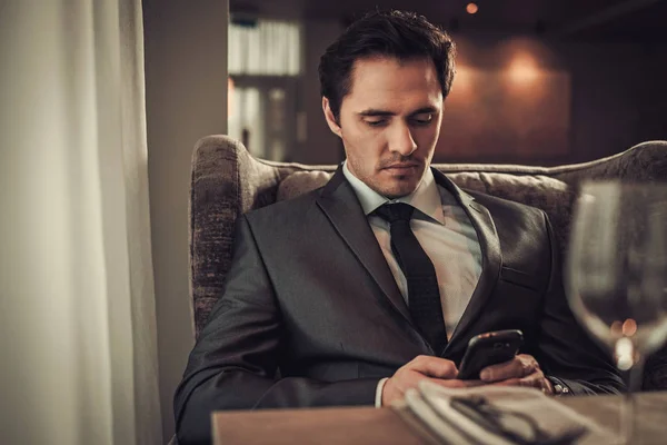 Selbstbewusster Mann mit Smartphone in Restaurant. — Stockfoto