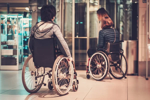 Két fogyatékkal élő nők várakozás-re egy lift — Stock Fotó