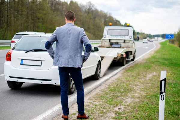 Hombre llamando mientras la grúa recoge su coche roto — Foto de Stock