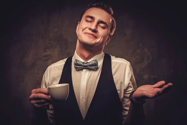 Sharp vestido homem vestindo colete com uma xícara de café — Fotografia de Stock