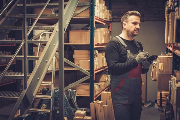 Opslaghouder met handheld barcodescanner werkt in een magazijn — Stockfoto