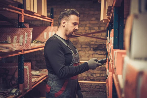 Penjaga toko dengan pemindai barcode genggam bekerja di sebuah gudang — Stok Foto
