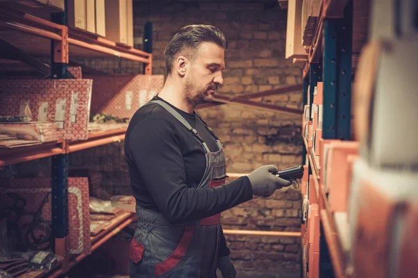 Storekeeper com scanner de código de barras portátil trabalhando em um armazém — Fotografia de Stock