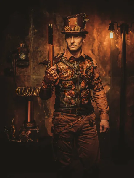 Человек-стемпанк с пистолетом на винтажном фоне стемпанка — стоковое фото