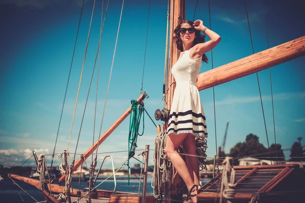 时尚富有的女人，对豪华木制帆船赛 — 图库照片