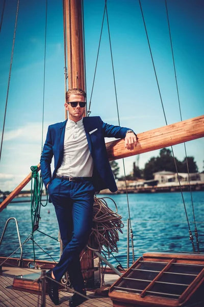 Stylish wealthy man on a luxury wooden regatta — Stock Photo, Image