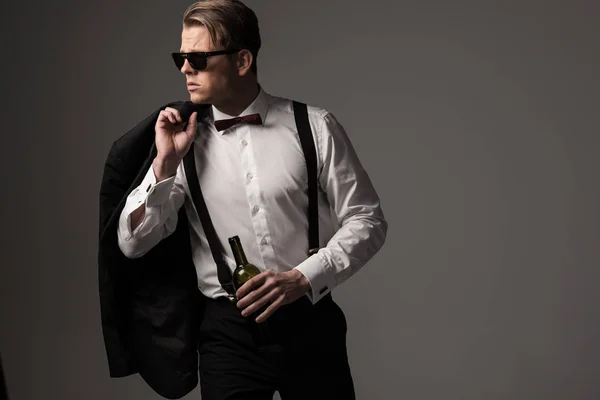 Uomo vestito affilato in abito nero con bottiglia di vino — Foto Stock