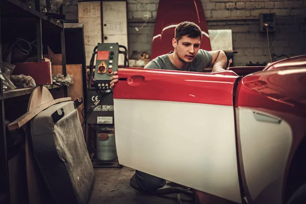 Mecánico trabajando en detalles de carrocería de coche en taller de restauración — Foto de Stock