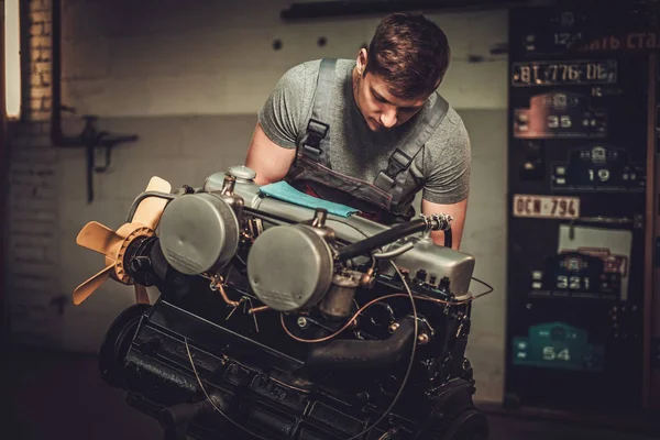 Mecânico de trabalho no motor de carro clássico na oficina de restauração — Fotografia de Stock