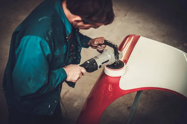 Mechaniker poliert Karosseriedetails in Restaurierungswerkstatt — Stockfoto