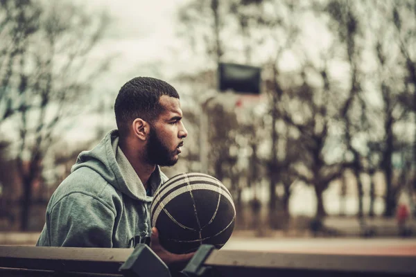 Speler van de Afro-Amerikaanse streetball rust buitenshuis — Stockfoto