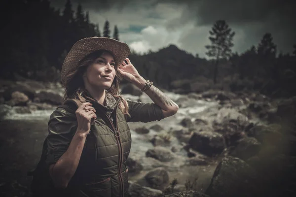 Mooie vrouw wandelaar in de buurt van wilde berg rivier. — Stockfoto