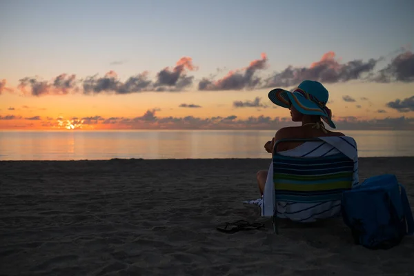 Nyugvó egyedül egy tengerparton a naplemente gyönyörű hölgy — Stock Fotó