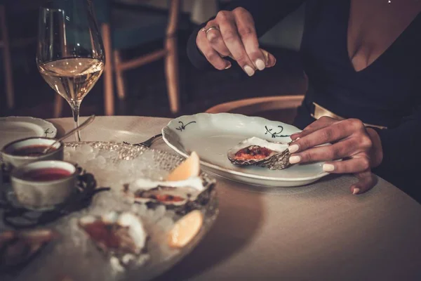 Žena jíst ústřice v restauraci — Stock fotografie