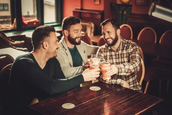 Allegro vecchi amici divertirsi e bere birra alla spina in pub . — Foto Stock