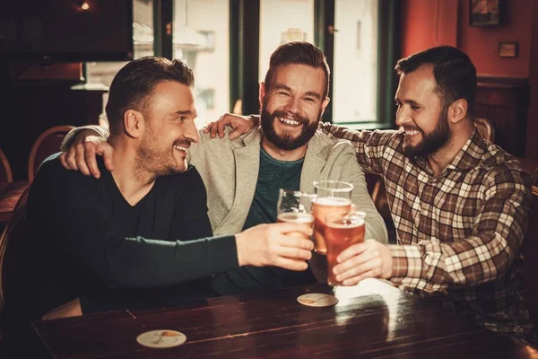 Allegro vecchi amici divertirsi e bere birra alla spina in pub . — Foto Stock