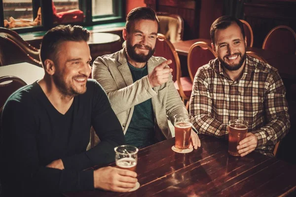 Allegro vecchi amici divertirsi e bere birra alla spina in pub . — Foto Stock