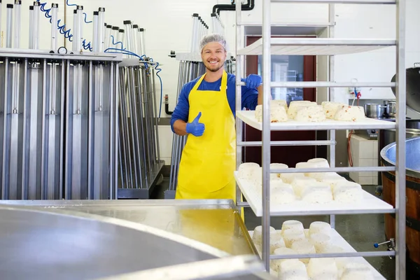 Knappe kaasproducent kwark in zijn fabriek te maken. — Stockfoto