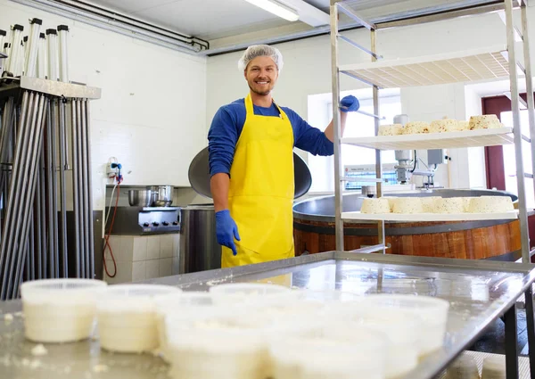 Bonito cheesemaker fazendo queijo coalhada em sua fábrica . — Fotografia de Stock