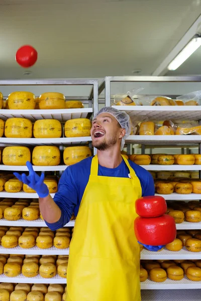 Handsome cheesemaker having fun in his workshop storage. — Stock Photo, Image