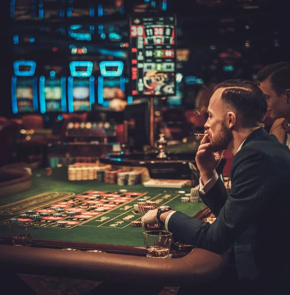 Amigos de classe alta jogando em um cassino — Fotografia de Stock