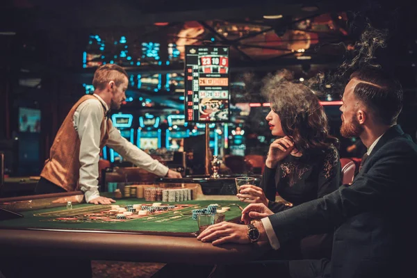 Casal de classe alta jogando em um cassino — Fotografia de Stock