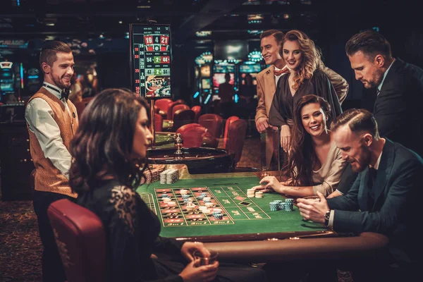 Des amis de la classe supérieure jouent dans un casino — Photo