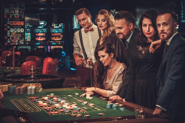 Amigos de clase alta jugando en un casino — Foto de Stock