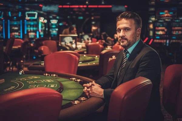 Ανώτερη τάξη ο άνθρωπος πίσω από τα τυχερά παιχνίδια τραπέζι σε μια χαρτοπαικτική λέσχη — Φωτογραφία Αρχείου
