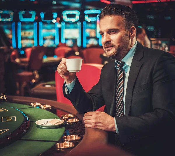 Homem de classe alta atrás da mesa de jogo em um cassino — Fotografia de Stock