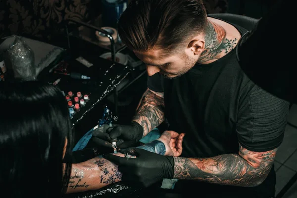 Professionele tattoo artiest maakt een tatoeage op een jonge meisjes hand — Stockfoto