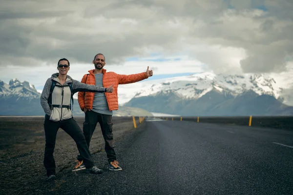 Viaje pareja autoestopista en una carretera —  Fotos de Stock