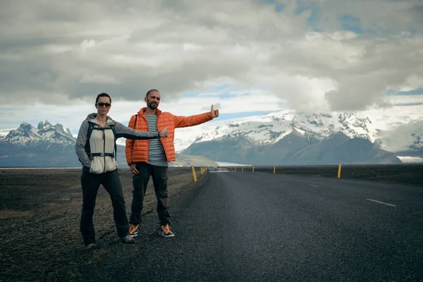 Travel hitchhiker couple on a road — Stock Photo, Image