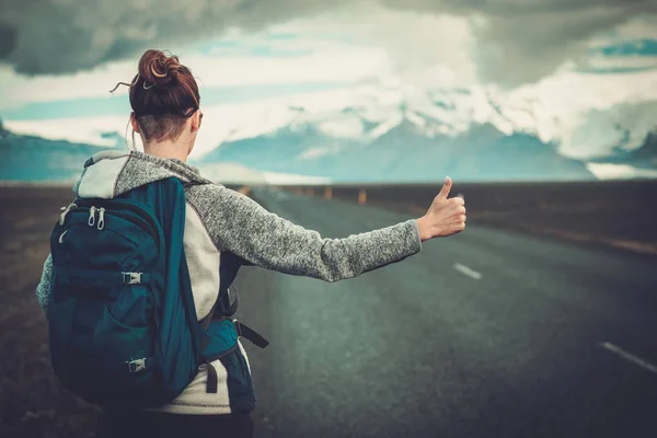 Viajes mujer autoestopista caminando por un camino —  Fotos de Stock