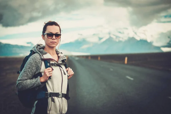 Ταξίδια hitchhiker γυναίκα το περπάτημα σε ένα δρόμο — Φωτογραφία Αρχείου