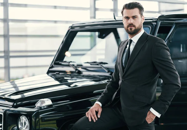 Well-dressed customer choosing new premium car at a dealership showroom — Stock Photo, Image