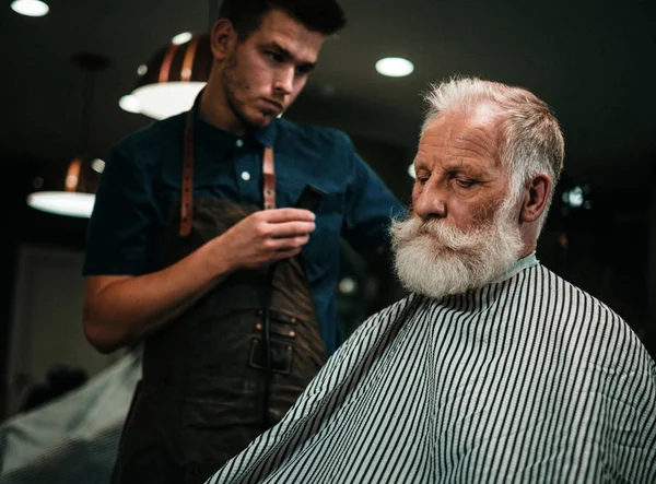 Hombre mayor visitando estilista en peluquería. — Foto de Stock