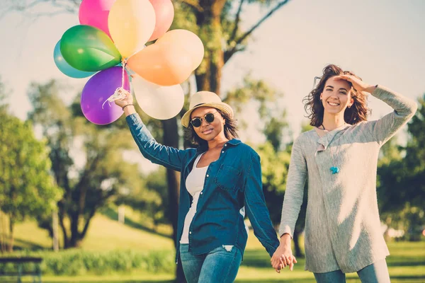 Casal feliz com balões de ar coloridos do arco-íris — Fotografia de Stock