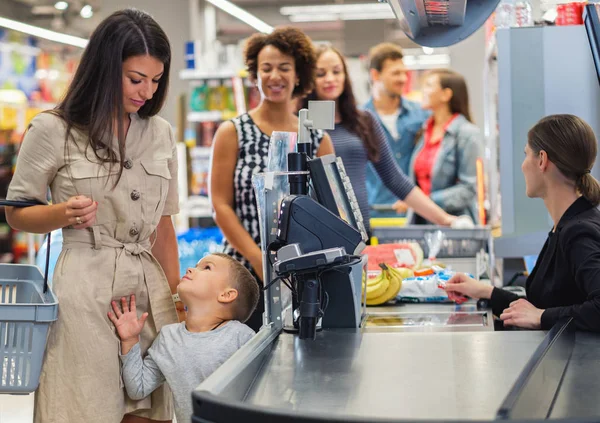 Woamn se synem v obchodě s potravinami — Stock fotografie