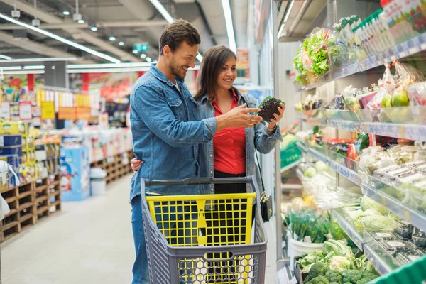 Couple choosing goods in a grocery store — Stock Photo, Image