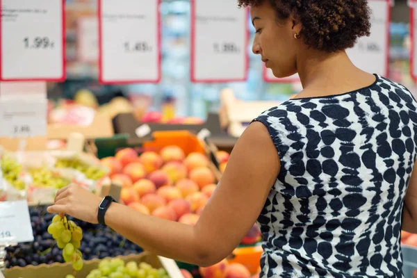 Woman choosing fruits in a grocery store — 스톡 사진