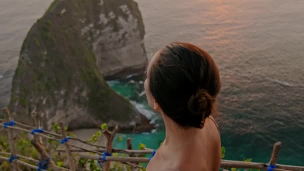 Женщина наслаждается видом на залив Манта на острове Нуса-Пенида, Бали, Индонезия — стоковое видео
