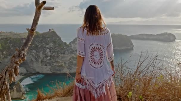 Женщина, наслаждающаяся видом на Алмазный залив, остров Нуса Пенида, Индонезия — стоковое видео